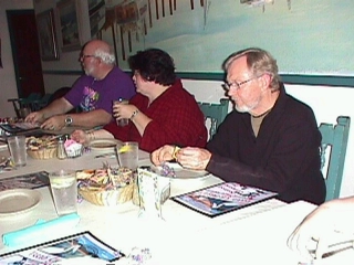 Image: Two men and a woman at the table.